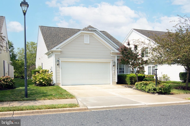 view of front of home with a front yard and a garage