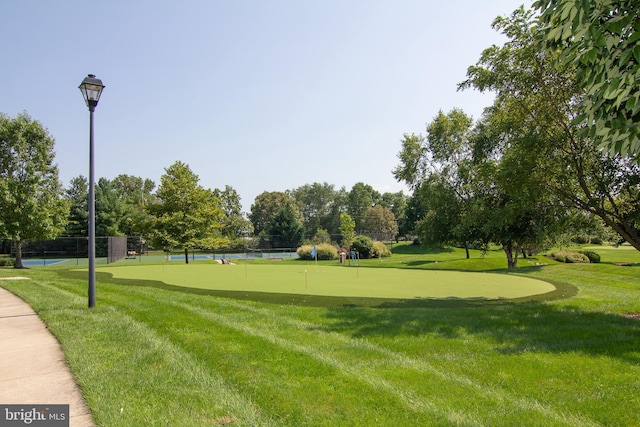 view of home's community with view of golf course and fence