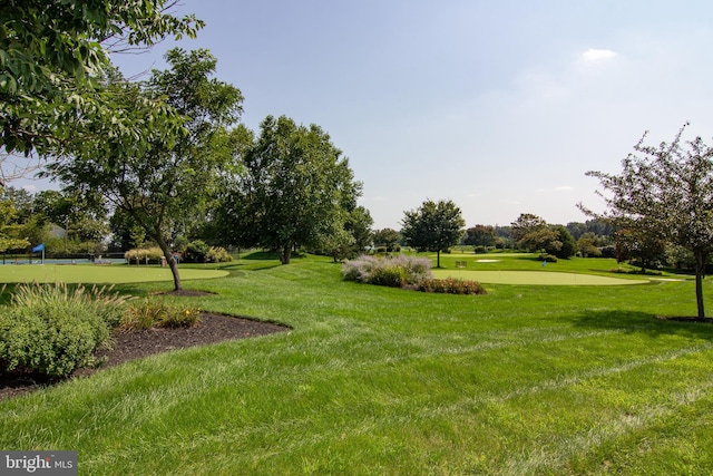 surrounding community featuring view of golf course and a yard