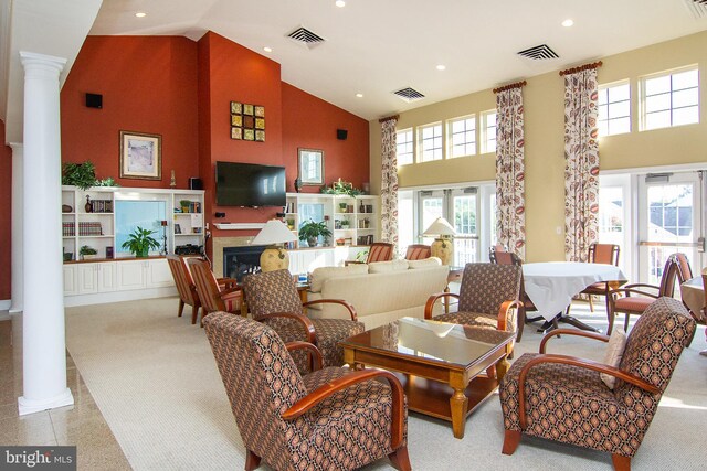 living room with high vaulted ceiling, a wealth of natural light, and ornate columns