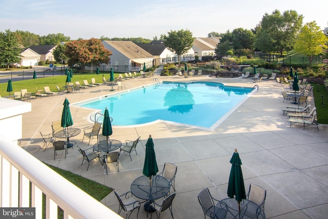 pool with a patio area and fence