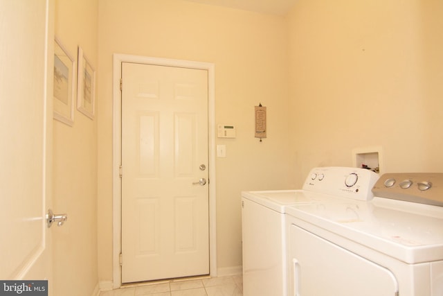 laundry area with washer and dryer, laundry area, light tile patterned flooring, and baseboards