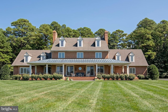 new england style home featuring covered porch and a front lawn