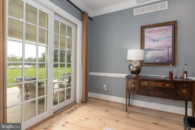 entryway featuring crown molding and light hardwood / wood-style flooring