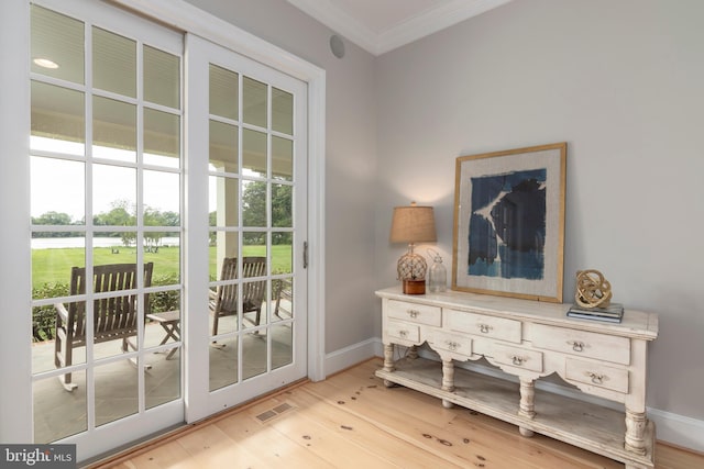 doorway featuring light wood-type flooring and ornamental molding