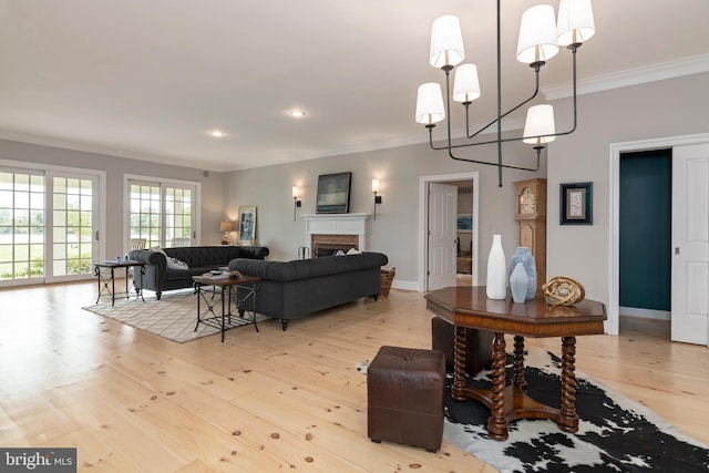 living room featuring crown molding, light hardwood / wood-style floors, and a notable chandelier