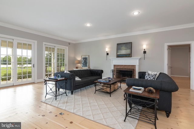 living room featuring ornamental molding, light hardwood / wood-style flooring, and a brick fireplace