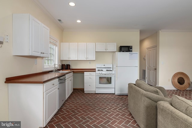 kitchen with white appliances, white cabinetry, ornamental molding, and sink