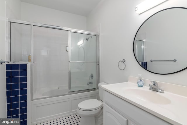 full bathroom featuring combined bath / shower with glass door, toilet, and vanity