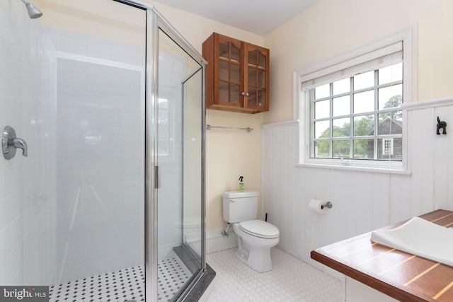 bathroom featuring toilet and a shower with door