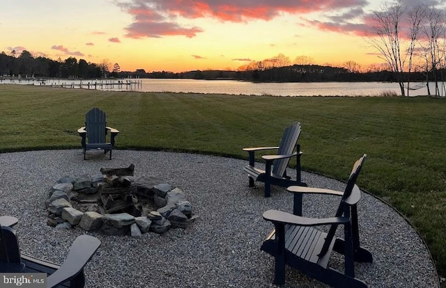 surrounding community featuring a yard, a water view, and an outdoor fire pit