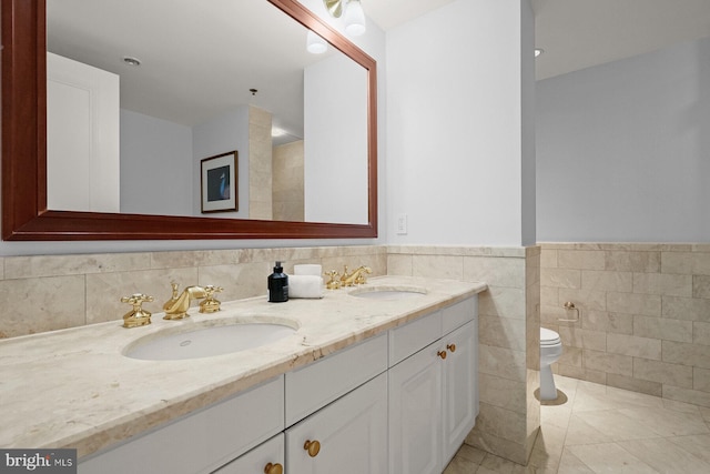 bathroom featuring toilet, tile patterned flooring, vanity, decorative backsplash, and tile walls