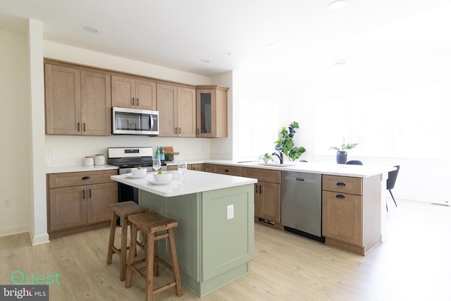 kitchen featuring appliances with stainless steel finishes, a center island, and light hardwood / wood-style floors