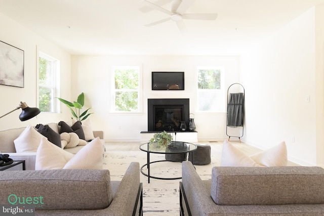 living room with light wood-type flooring, plenty of natural light, and ceiling fan