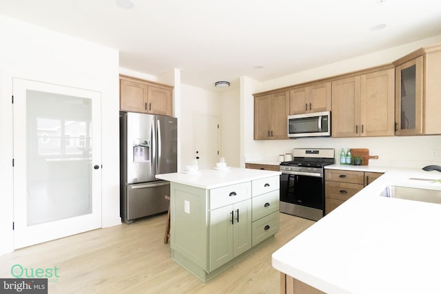 kitchen featuring a center island, sink, appliances with stainless steel finishes, and light hardwood / wood-style floors