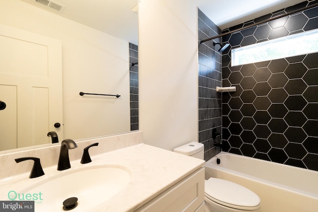 full bathroom featuring tiled shower / bath, toilet, and vanity