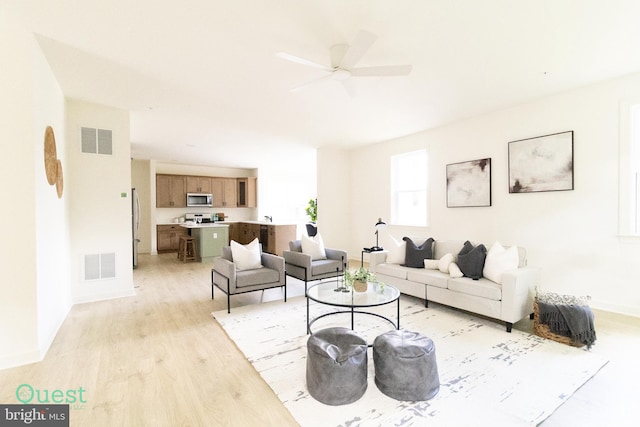 living room with light hardwood / wood-style flooring and ceiling fan