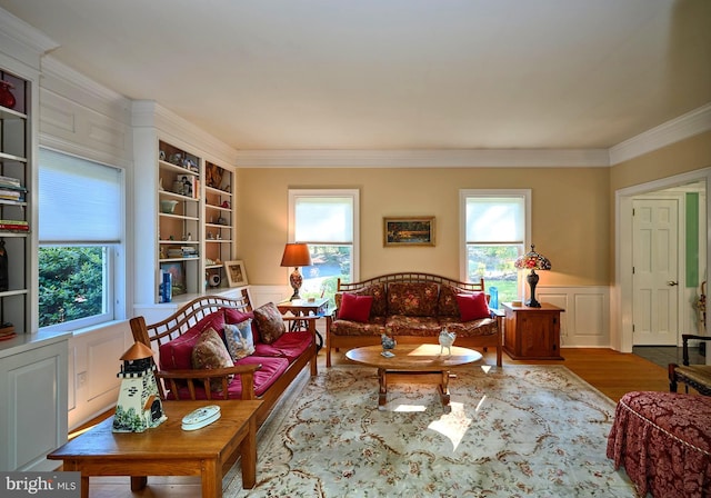 living room with wood-type flooring, a wealth of natural light, and crown molding