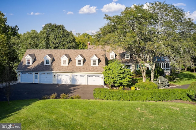 new england style home featuring a garage and a front yard