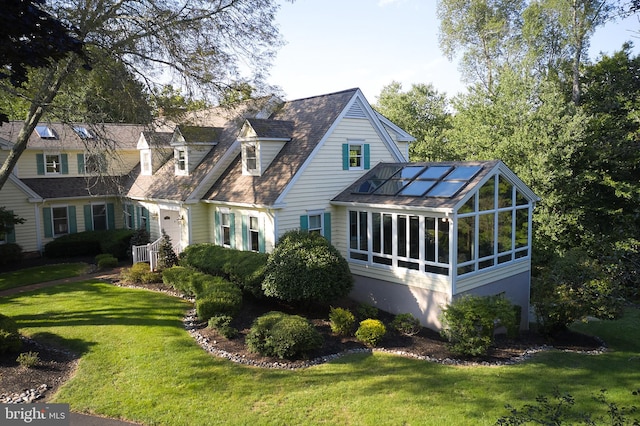 exterior space with a sunroom and a lawn