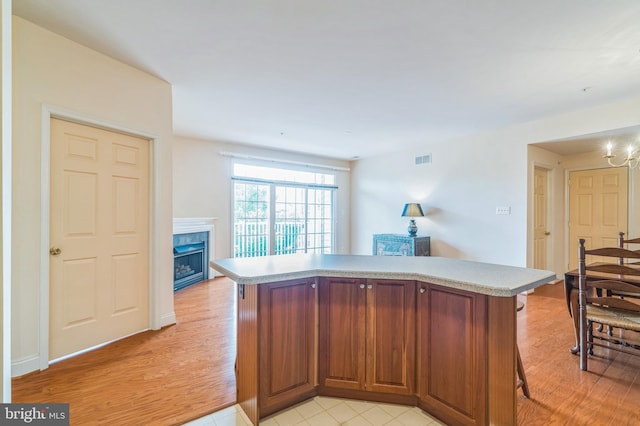 kitchen with a kitchen bar and light hardwood / wood-style flooring