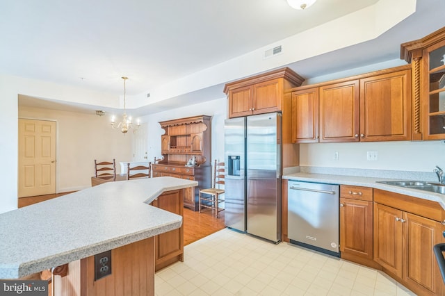 kitchen with pendant lighting, sink, light tile patterned floors, and appliances with stainless steel finishes