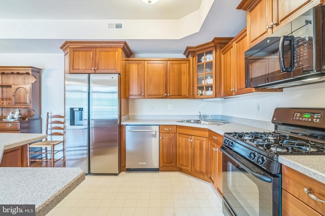 kitchen with black appliances, light tile patterned floors, and sink