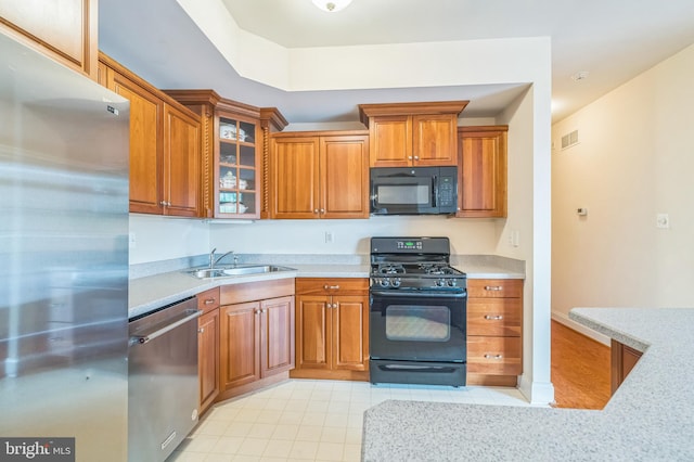 kitchen with black appliances, sink, and light tile patterned floors