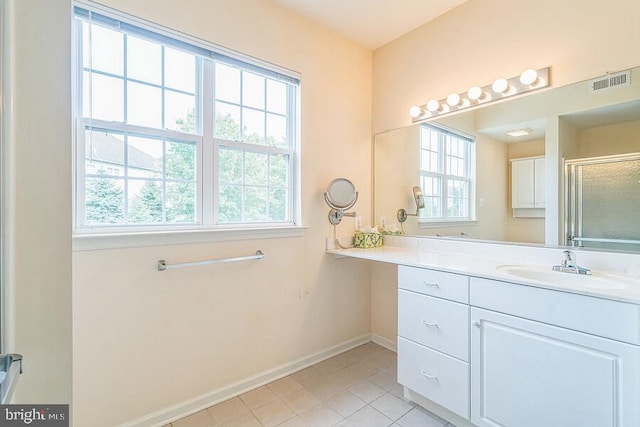 bathroom with a shower with door, plenty of natural light, and tile patterned flooring