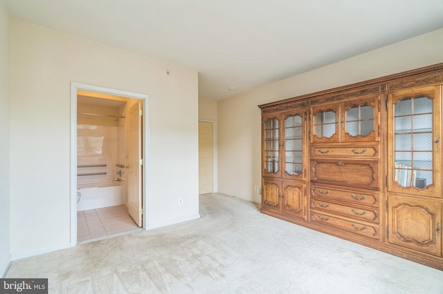 unfurnished bedroom with light colored carpet and ensuite bathroom