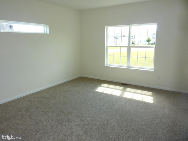 carpeted empty room featuring visible vents and baseboards