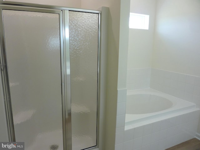 full bathroom featuring a stall shower and a garden tub