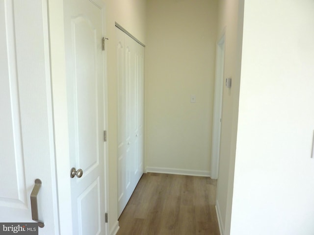 hall with light wood finished floors and baseboards