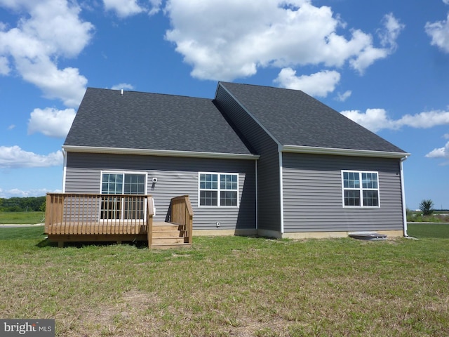 back of house featuring a wooden deck, a shingled roof, and a yard