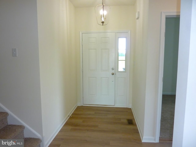 foyer entrance with stairs, wood finished floors, visible vents, and baseboards