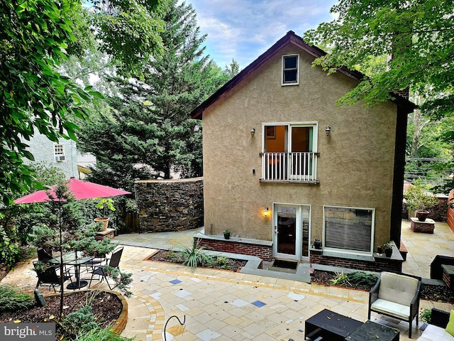 back of house featuring a patio area and stucco siding