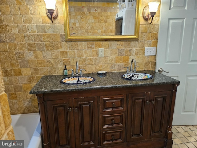 bathroom featuring tile patterned flooring, vanity, a bathtub, and backsplash