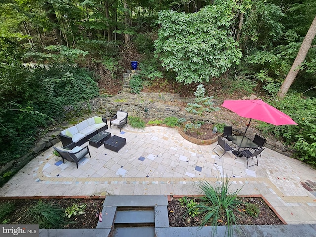 view of patio with an outdoor living space with a fire pit