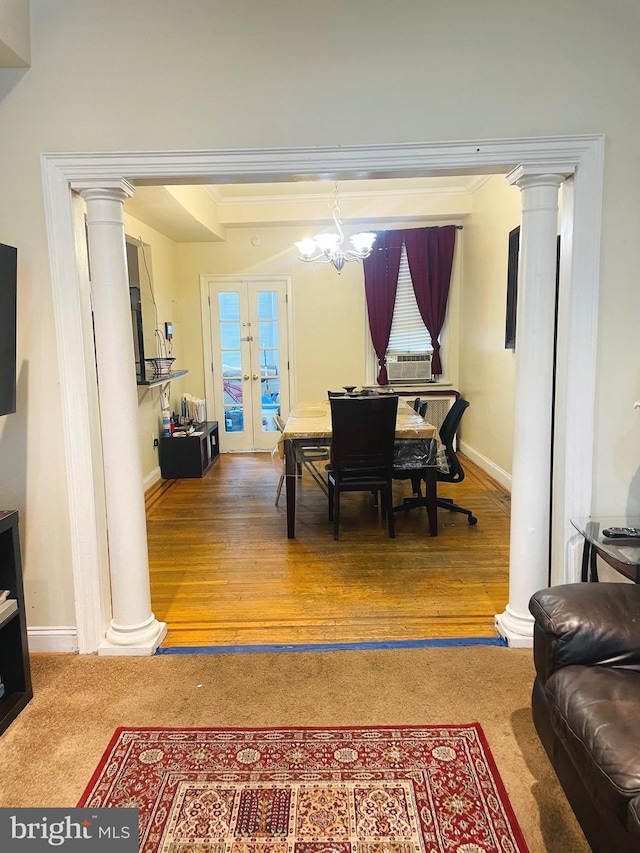 dining space with decorative columns, hardwood / wood-style floors, and french doors