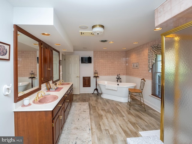 bathroom with hardwood / wood-style floors, vanity, tile walls, and separate shower and tub