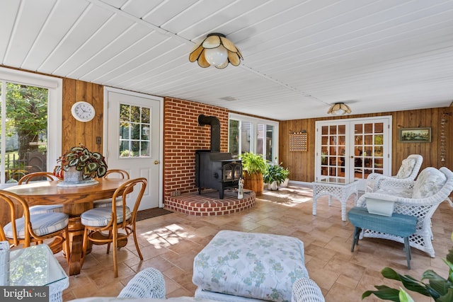 sunroom featuring a wood stove and french doors