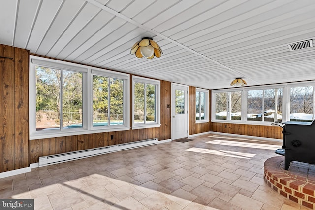 unfurnished sunroom with wood ceiling, a wood stove, and a baseboard radiator