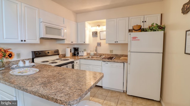 kitchen featuring light tile patterned flooring, white cabinetry, sink, kitchen peninsula, and white appliances