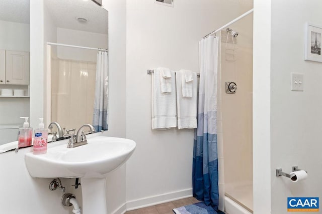 bathroom featuring a textured ceiling and a shower with curtain