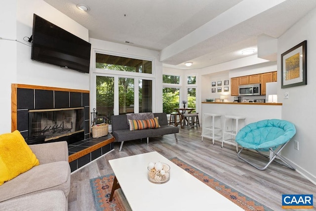 living room with a tile fireplace and wood-type flooring