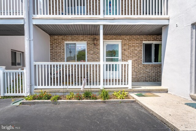 entrance to property featuring a balcony and a porch