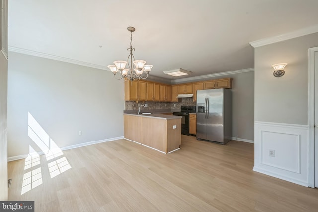 kitchen with stainless steel fridge, black electric range oven, a peninsula, under cabinet range hood, and a sink