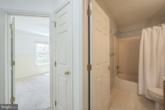 bathroom featuring shower / bath combo, tile patterned flooring, toilet, and baseboards