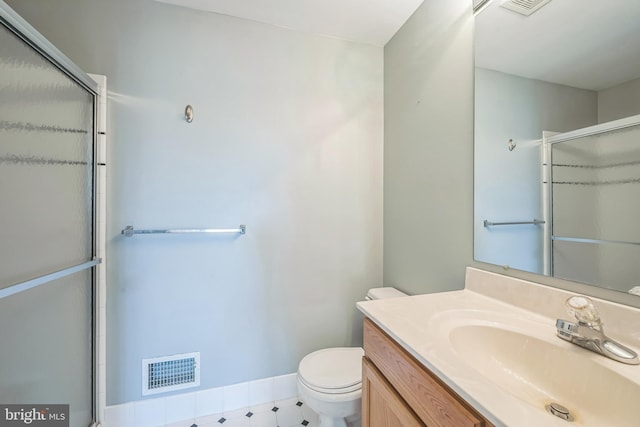 full bath featuring toilet, vanity, visible vents, baseboards, and an enclosed shower