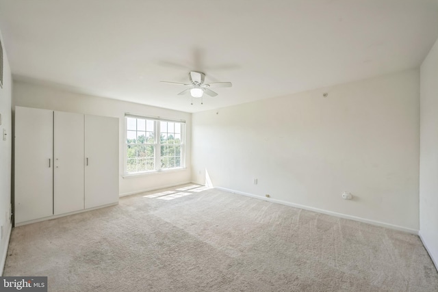 unfurnished bedroom featuring carpet, baseboards, and ceiling fan